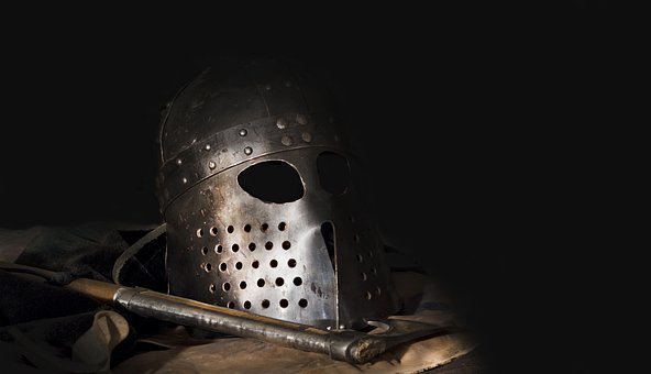 a black metal helmet on a wooden table with dark lighting